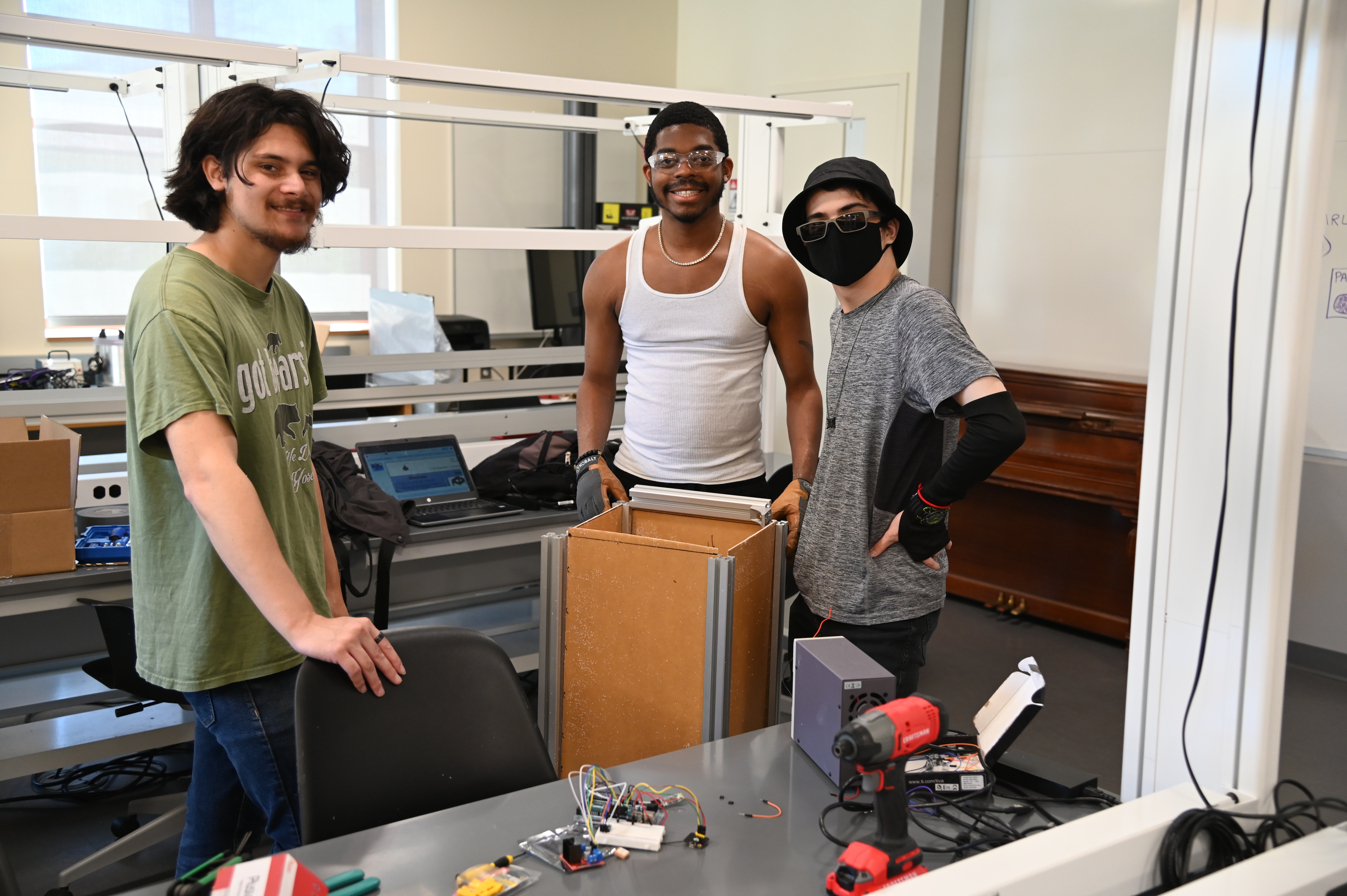Bennett Rousseau, Quentin Thomas, and Kc Hebrard (left to right) are building an autonomous items carrier - portable story. Users connect via Bluetooth, and this portable storage unit will follow a person around using GPS location.