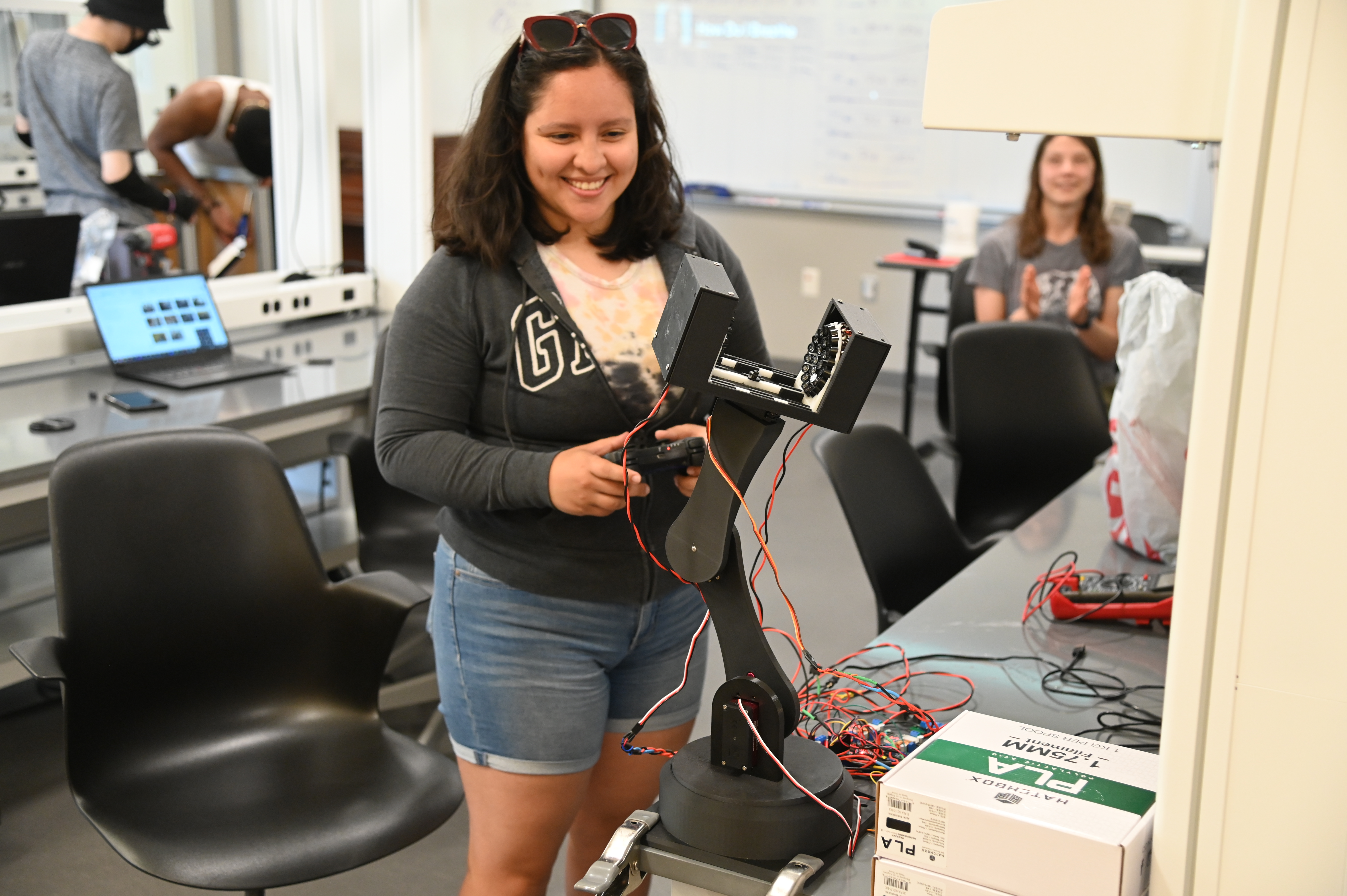 Keily Valdez Sereno uses a Playstation controller to manipulate the robotic arm of an acoustic levitator. The robotic arm is made with 3D printed parts, that she designed in Fusion360 CAD Software.