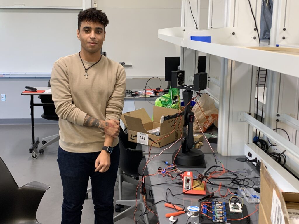 Thomas Adams, a dual major in Physics and Mechatronics Engineering, with the acoustic levitator elements that he himself designed.