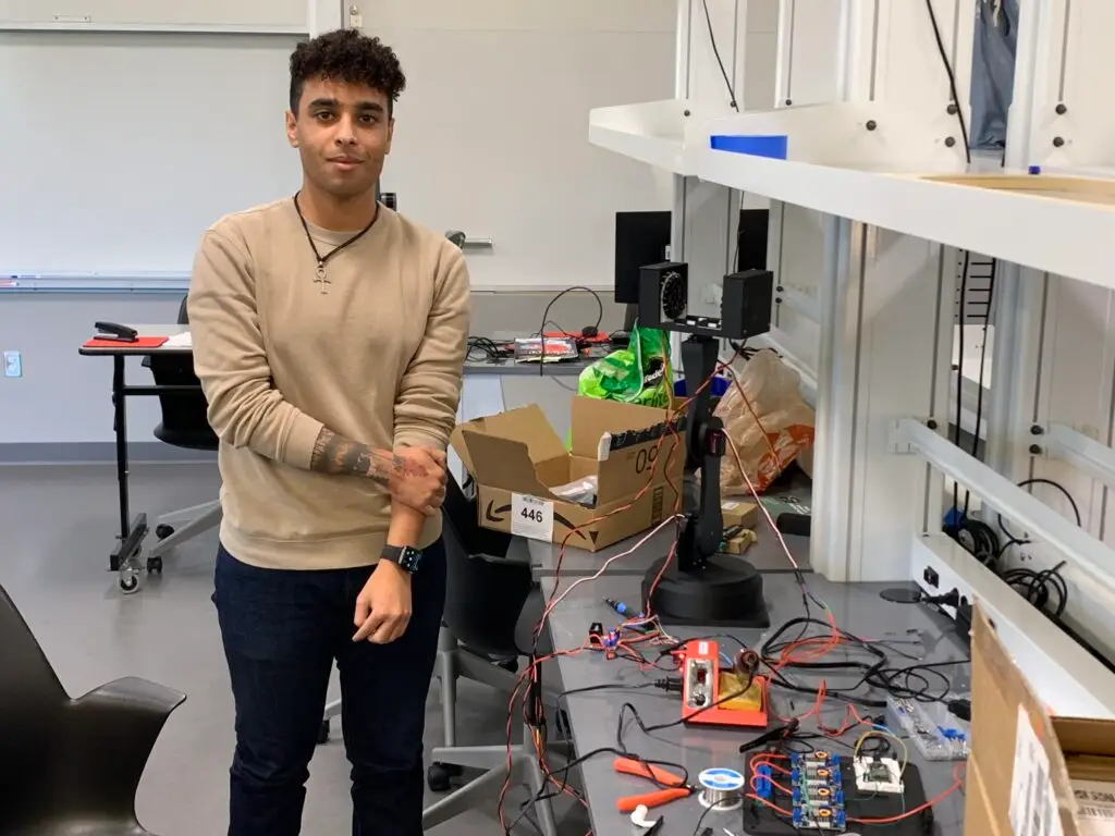Thomas Adams, a dual major in Physics and Mechatronics Engineering, with the acoustic levitator elements that he himself designed.